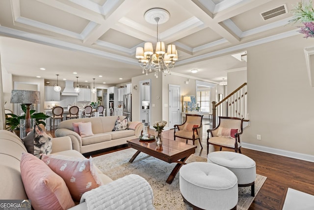 living area featuring visible vents, coffered ceiling, dark wood finished floors, an inviting chandelier, and baseboards