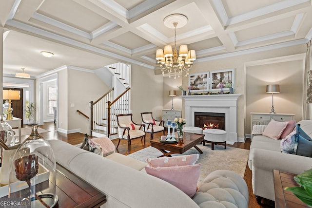 living room featuring wood finished floors, coffered ceiling, beam ceiling, a lit fireplace, and stairs