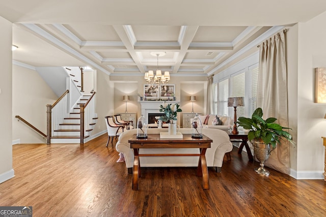 interior space featuring beam ceiling, a warm lit fireplace, wood finished floors, baseboards, and stairs