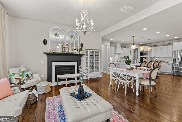 living room with recessed lighting, visible vents, a glass covered fireplace, and dark wood finished floors