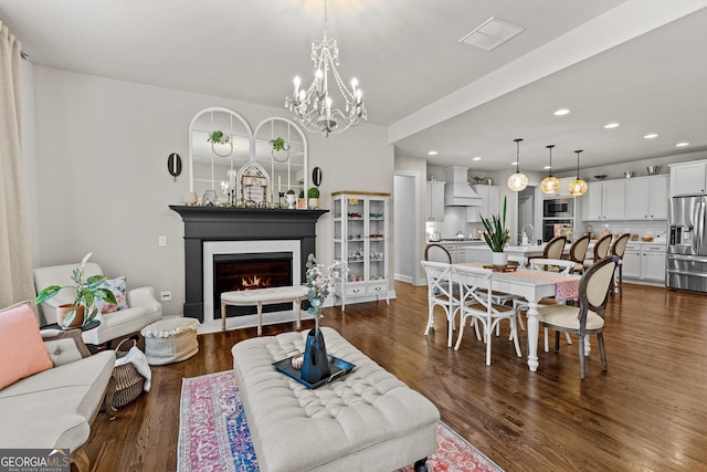 living area featuring dark wood-type flooring, recessed lighting, and a lit fireplace