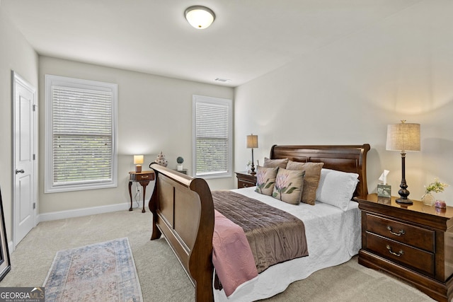 bedroom with light carpet, visible vents, and baseboards