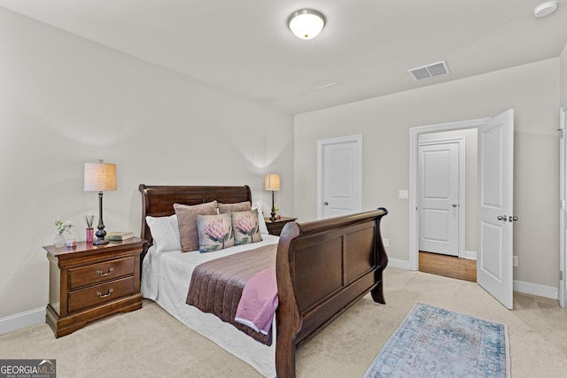 bedroom with light colored carpet, visible vents, and baseboards