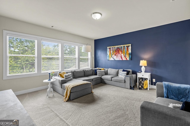 living area with visible vents, baseboards, and carpet flooring