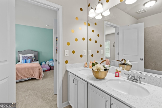 bathroom with a sink, connected bathroom, visible vents, and double vanity