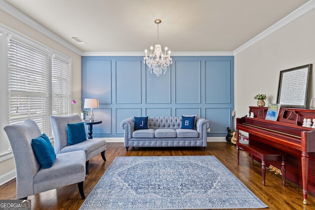 living room with dark wood-style floors, visible vents, ornamental molding, a decorative wall, and a notable chandelier