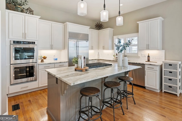 kitchen with visible vents, white cabinetry, and stainless steel appliances