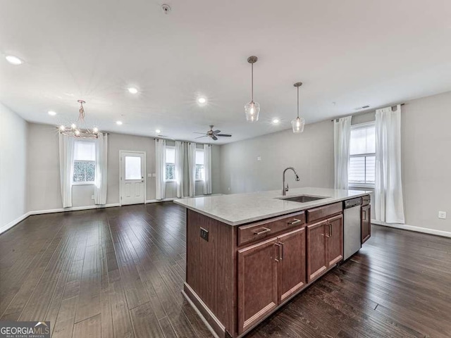 kitchen featuring a sink, open floor plan, dishwasher, light countertops, and dark wood-style flooring