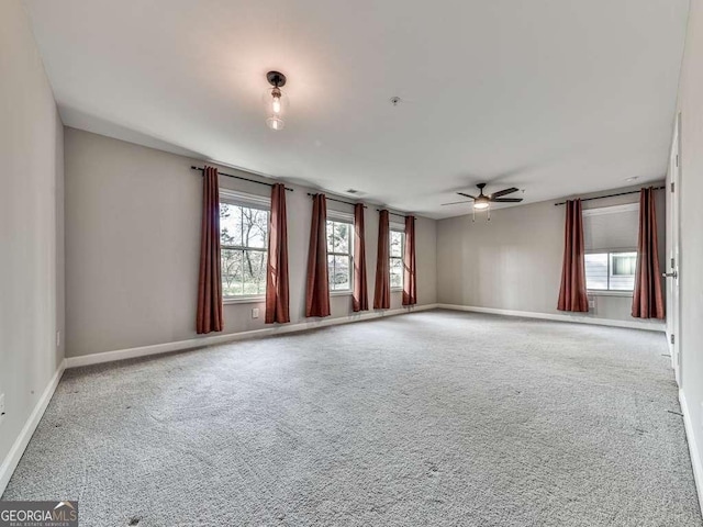 spare room with baseboards, carpet, and a ceiling fan