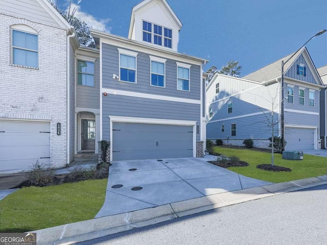 view of front of house with concrete driveway, a front yard, and a garage