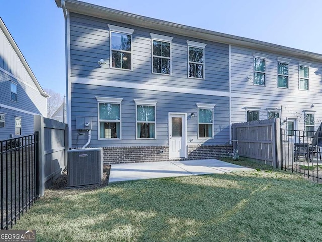 back of property featuring a patio, a lawn, central AC, and a fenced backyard