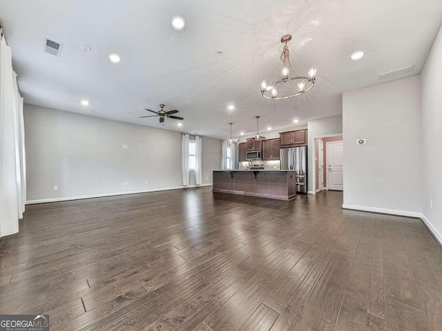 unfurnished living room featuring recessed lighting, visible vents, dark wood-style floors, and ceiling fan with notable chandelier