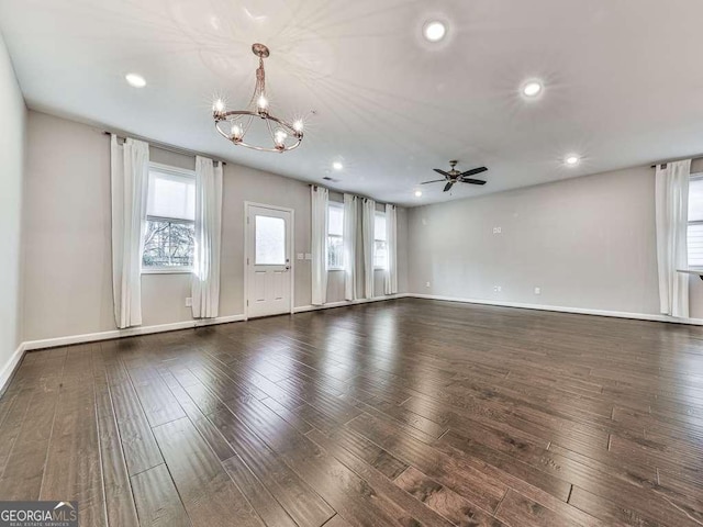 unfurnished living room with recessed lighting, ceiling fan with notable chandelier, baseboards, and wood finished floors