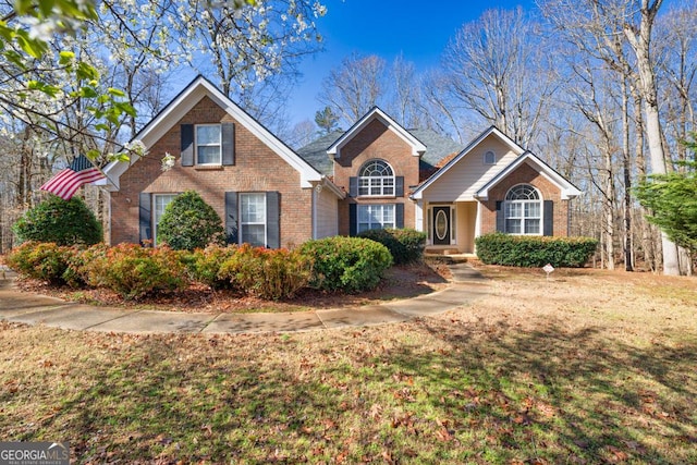 traditional-style house with brick siding and a front yard