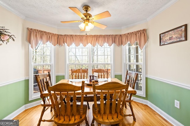 dining space with baseboards, light wood-style floors, ceiling fan, and a textured ceiling