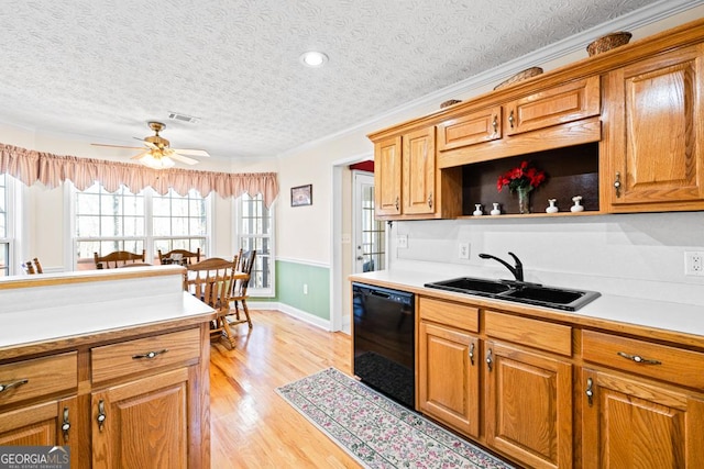 kitchen with visible vents, light wood-type flooring, a sink, black dishwasher, and light countertops