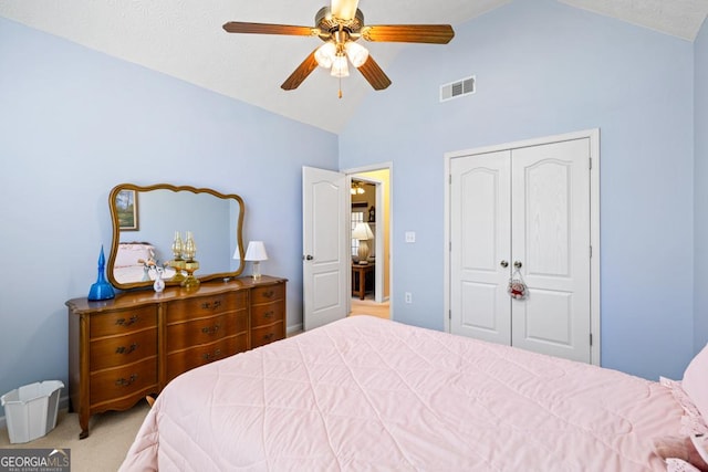 bedroom with visible vents, vaulted ceiling, light carpet, a closet, and a ceiling fan