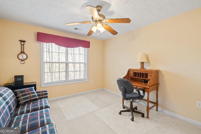 carpeted office space featuring visible vents, baseboards, a textured ceiling, and a ceiling fan