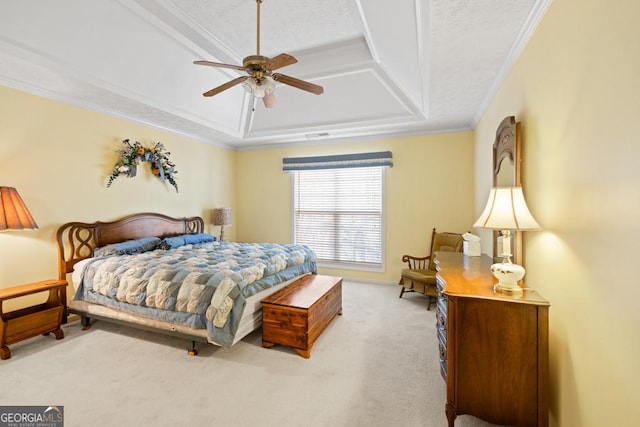 carpeted bedroom with a textured ceiling, a ceiling fan, crown molding, and a tray ceiling