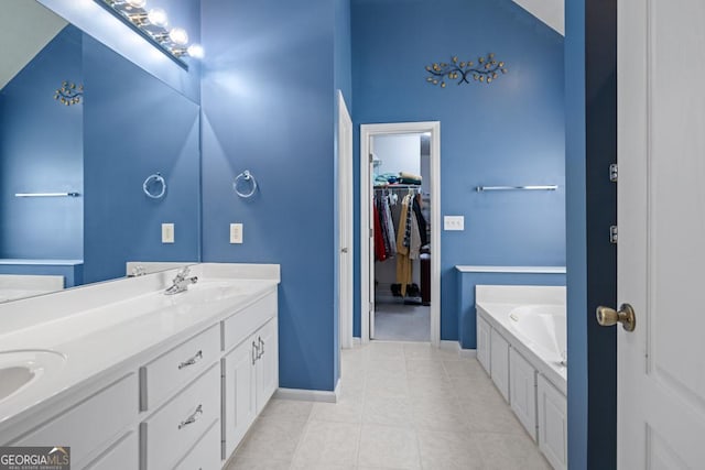 full bath with a sink, tile patterned flooring, double vanity, a bath, and a spacious closet