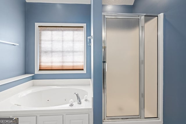 bathroom with a jetted tub and a stall shower