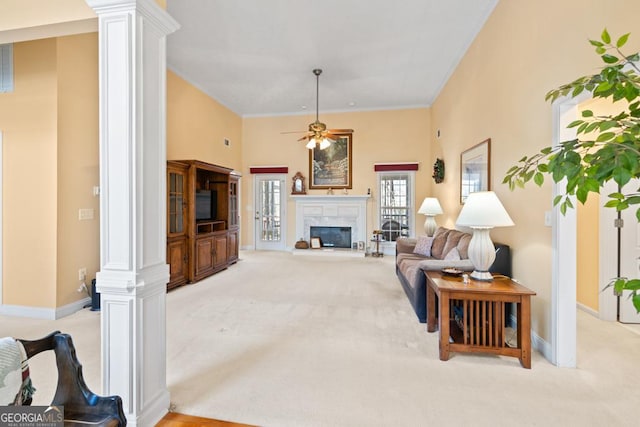 living area with decorative columns, a premium fireplace, and carpet flooring