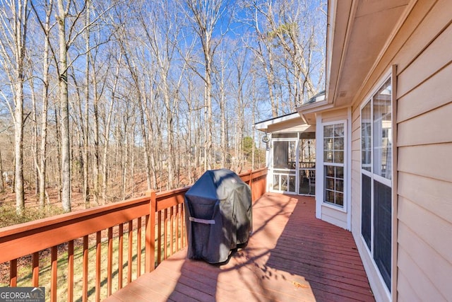 deck with grilling area and a sunroom