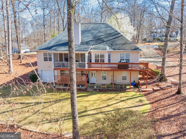 back of house featuring stairway, a wooden deck, roof with shingles, a yard, and an attached garage