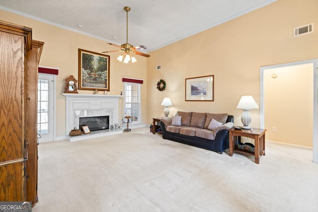 living room with crown molding, visible vents, carpet floors, and a premium fireplace