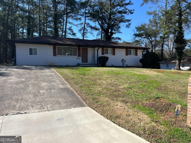 ranch-style home with brick siding, concrete driveway, and a front lawn