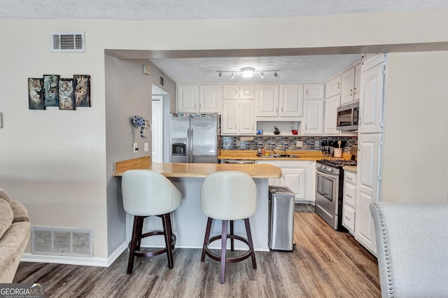 5545 Circlestone Ln, Stone Mountain, GA 30083 - kitchen with visible vents, a kitchen bar, appliances with stainless steel finishes, and light countertops