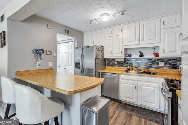 5545 Circlestone Ln, Stone Mountain, GA 30083 - kitchen with a sink, a peninsula, visible vents, and stainless steel appliances