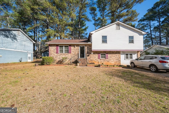 tri-level home with brick siding and a front lawn