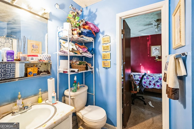 ensuite bathroom with vanity, ceiling fan, ensuite bathroom, a textured ceiling, and toilet