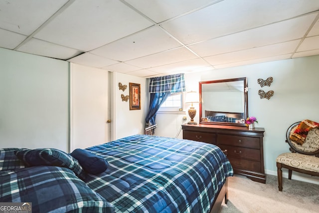 bedroom with a paneled ceiling and carpet floors