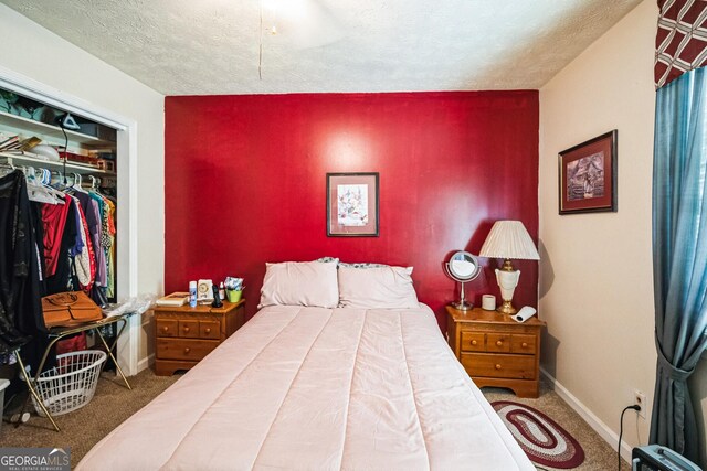 bedroom with a closet, baseboards, carpet, and a textured ceiling