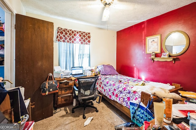 bedroom with a textured ceiling, carpet, and a ceiling fan