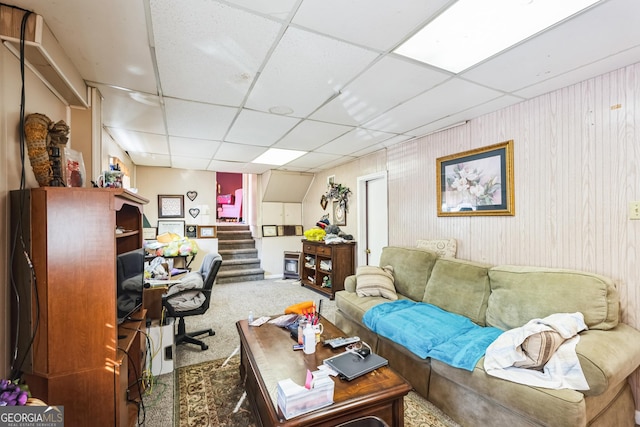 carpeted living room with stairs and a paneled ceiling