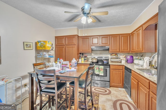 kitchen with light stone counters, a sink, under cabinet range hood, appliances with stainless steel finishes, and backsplash