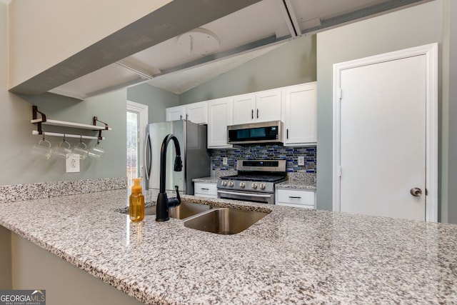 kitchen with light stone counters, tasteful backsplash, stainless steel appliances, white cabinets, and vaulted ceiling with beams