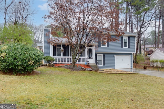 split level home featuring a front yard, covered porch, a chimney, driveway, and an attached garage