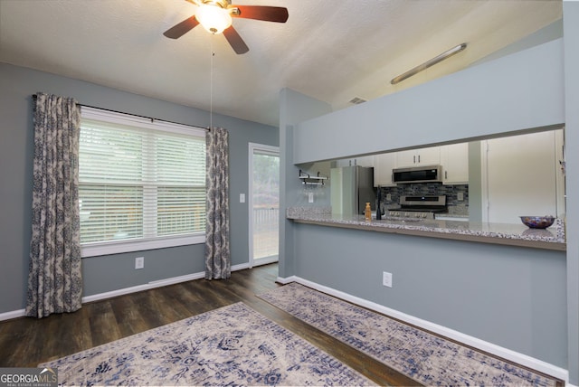 kitchen featuring visible vents, decorative backsplash, wood finished floors, white cabinets, and stainless steel appliances