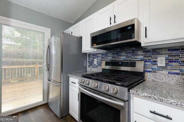 kitchen with light stone countertops, dark wood finished floors, decorative backsplash, stainless steel appliances, and white cabinetry