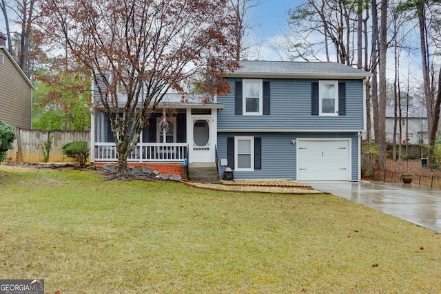 tri-level home featuring a front lawn, fence, concrete driveway, covered porch, and a garage