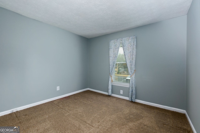 empty room with baseboards, carpet floors, and a textured ceiling