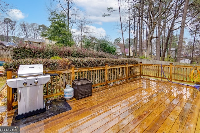 wooden terrace featuring grilling area and fence