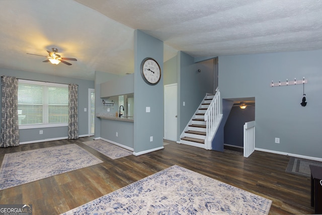 living room with wood finished floors, stairs, baseboards, and vaulted ceiling