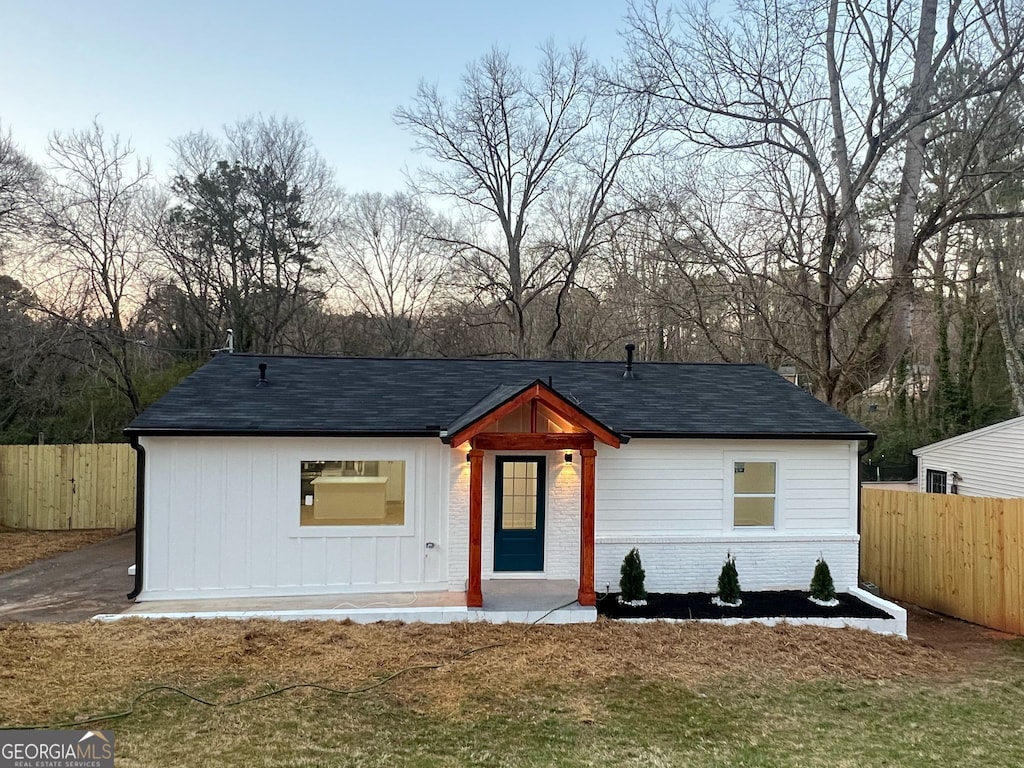 view of front facade featuring fence and brick siding