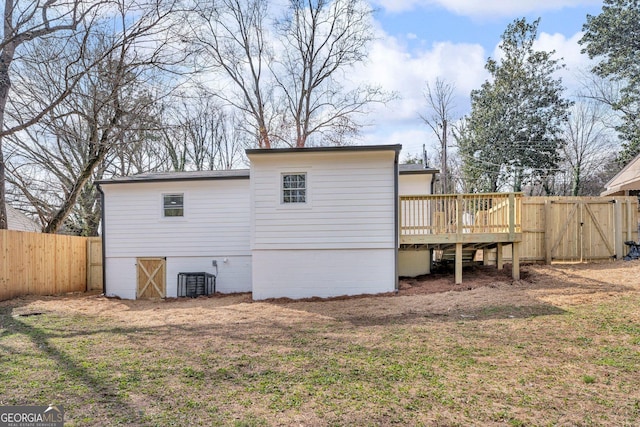 926 Natham Dr SE, Atlanta, GA 30315 - back of property featuring a fenced backyard, central AC unit, a deck, a gate, and a lawn