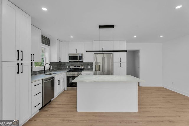926 Natham Dr SE, Atlanta, GA 30315 - kitchen featuring a sink, white cabinetry, a center island, stainless steel appliances, and decorative backsplash